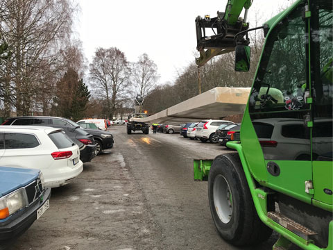 Transport av lång limträbalk med teleskoplastare på byggarbetsplatsen.